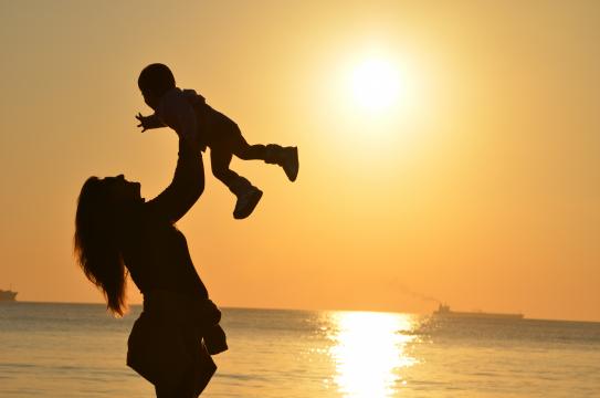夕阳下妈妈抱着孩子笑