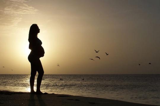 夕阳下怀孕的女人